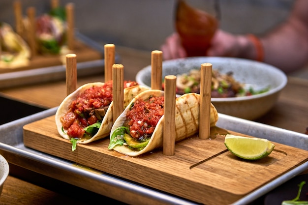 Traditional street mexican pork tacos with beef, avocado, chilli and onions in yellow corn tortilla.