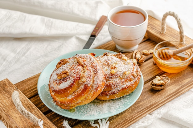 Traditional Swedish bakery or kanelbulle with walnuts on wooden tray