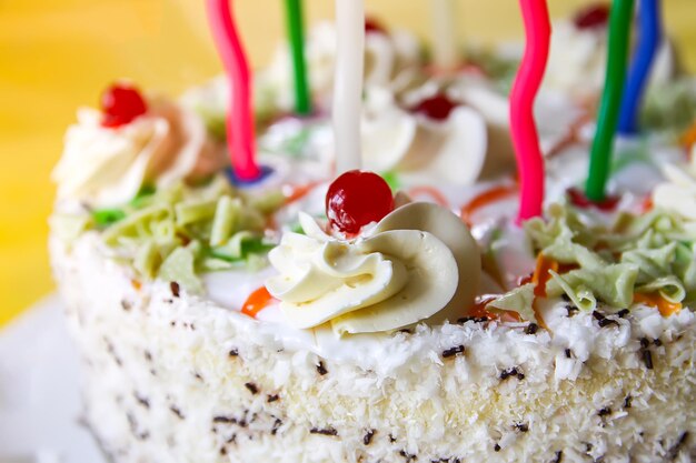 Traditional sweet birthday cake with colorful candles.