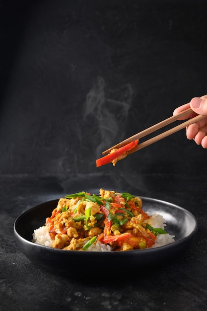 Traditional thai breakfast gai pad pongali with chicken eggs spicy yellow thai curry paste on rice