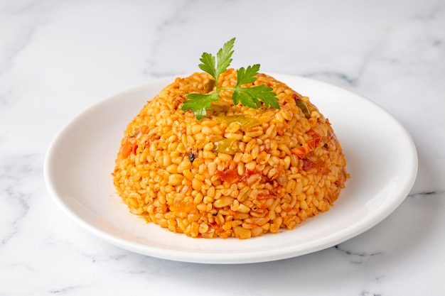 Traditional turkish bulgur pilaf with tomato sause in plate (Turkish name; meyhane pilavi)