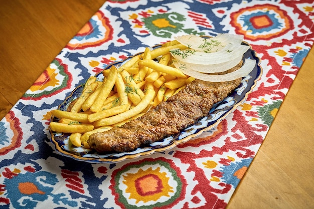 Traditional Turkish lula kebab made of minced meat served on a plate with french fries