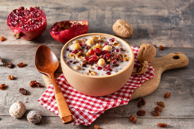 Traditional Turkish Noah's pudding in bowl on wooden table