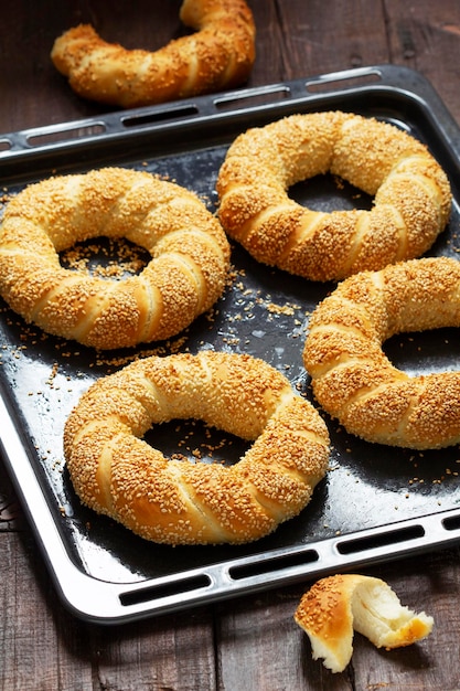 Traditional Turkish simits with sesame seeds on a wooden background. Rustic style, selective focus.