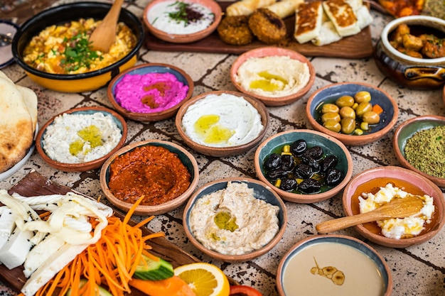 Traditional Turkish Village Breakfast on the ceramic table with pastries vegetables greens spreads cheeses fried eggs jams Top view