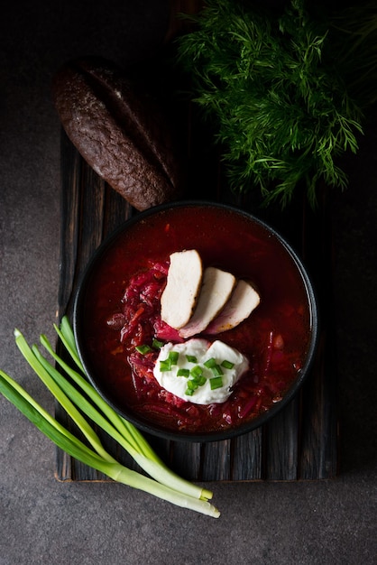 Traditional Ukrainian cuisine - borscht with sour cream and green onions, top view