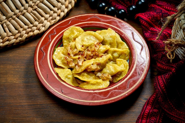 Traditional Ukrainian varenyky with meat and fried onions in clay dishes Ukrainian cuisine