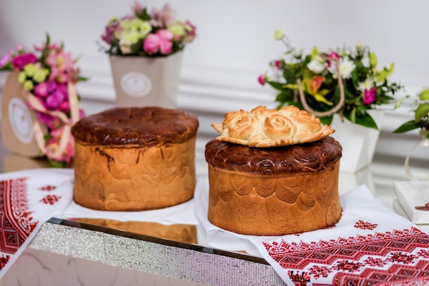 Traditional wedding Ukrainian bread Korovai and cake with flowers