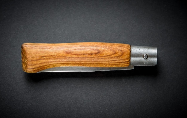 Traditional wooden pocket knife on a black background