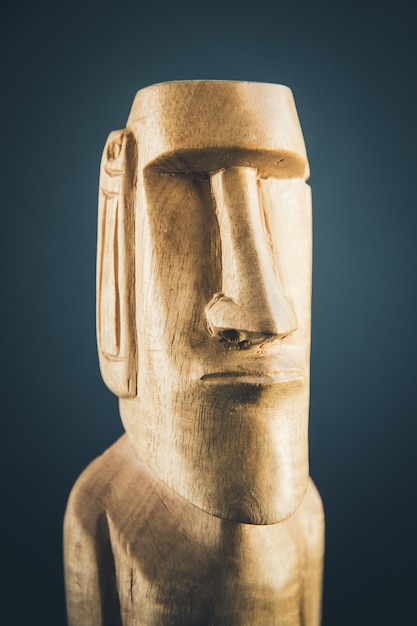 Traditional wooden statue of a moai from Easter Island. Dark background