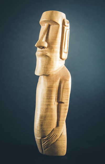 Traditional wooden statue of a moai from Easter Island. Dark background