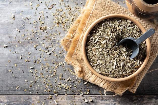 Traditional yerba mate in bowl on wooden table