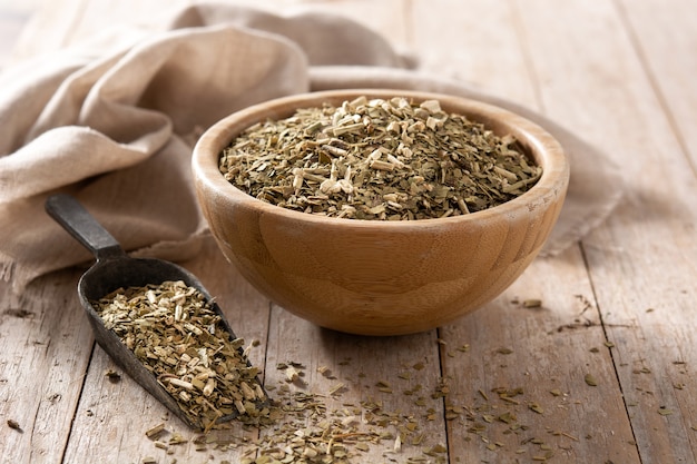 Traditional yerba mate tea in bowl on wooden table