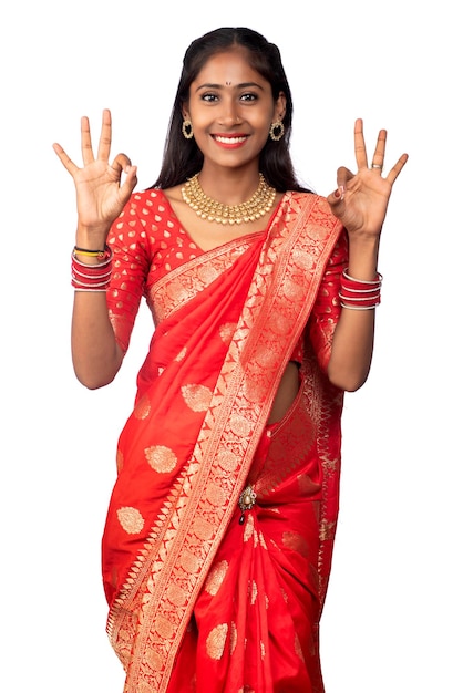 Traditional young smiling girl showing ok sign or thumbs up on a white background