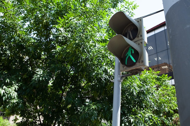 Traffic light in the city is lit green for pedestrians