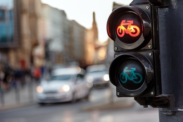 Traffic lights for bicycles lights red on a background of moving cars in the evening on a city street