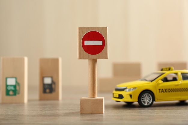 Traffic sign No entry and toy taxi car on wooden table Passing driving license exam