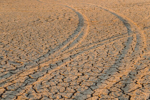 Photo trail of a car on dry cracked groundenvironmental disaster greenhouse effect