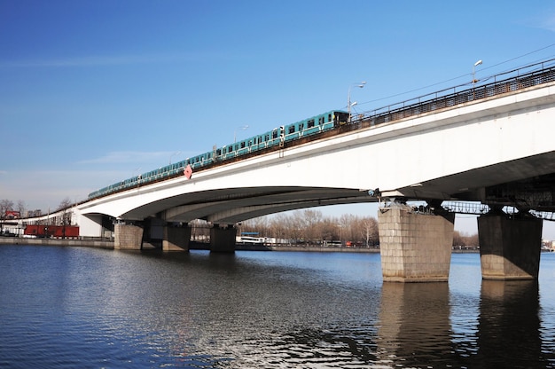 A train is going over a bridge that has the word " g. " on it.