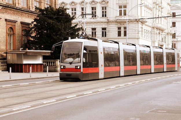 A train is going down the street in front of a building.