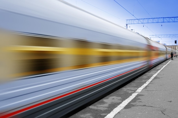 A train passing by with a blurry train passing by.