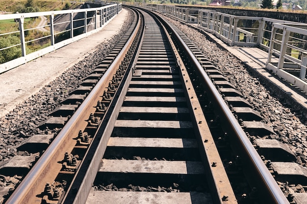 Train rails in country landscape. Railroad tracks at sunset time. Local travel concept.