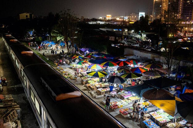 train traveling down tracks next to a market