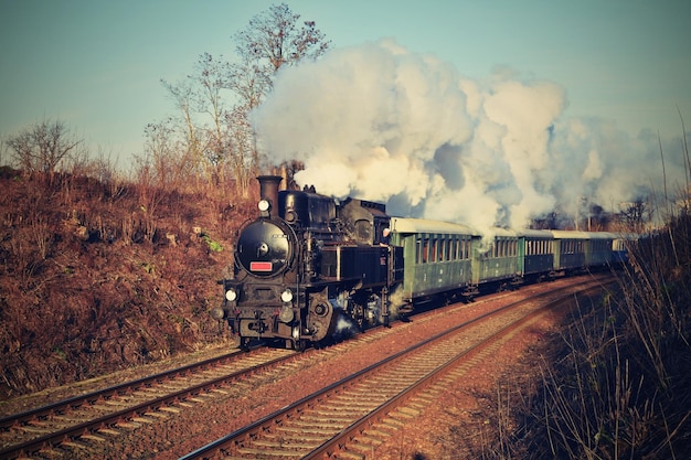 A train with the number 2 on it is on a track with smoke coming out of it.