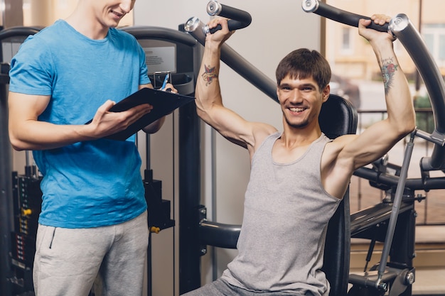 Trainer controls the physical exercise of the man