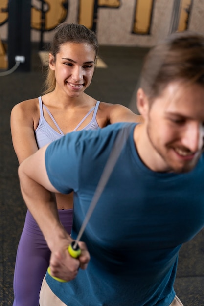 Trainer helping beginner at the gym