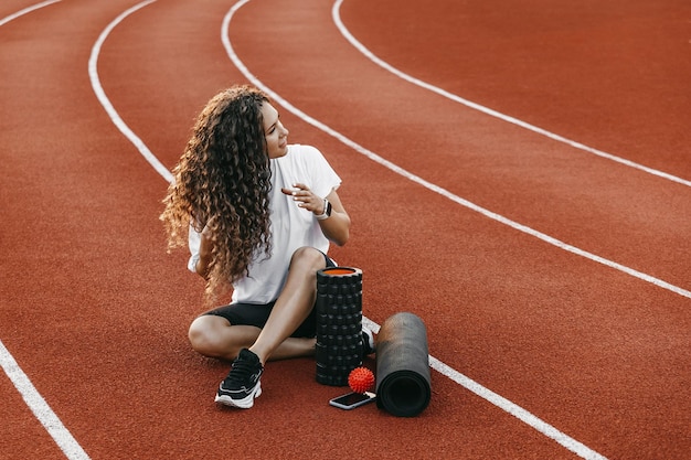 Trainer sitting at a stadium near her training equipment.