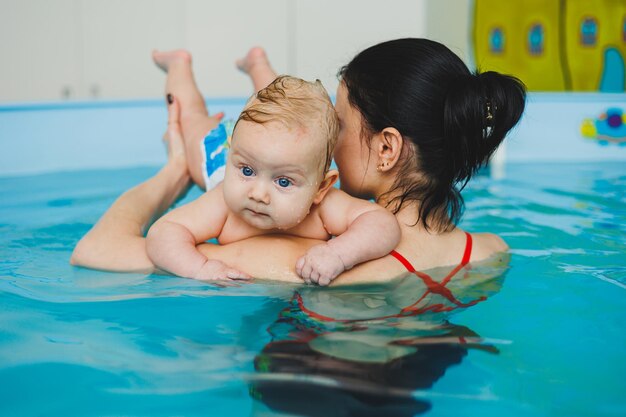 Trainer teaches baby to swim swimming pool for children Child development