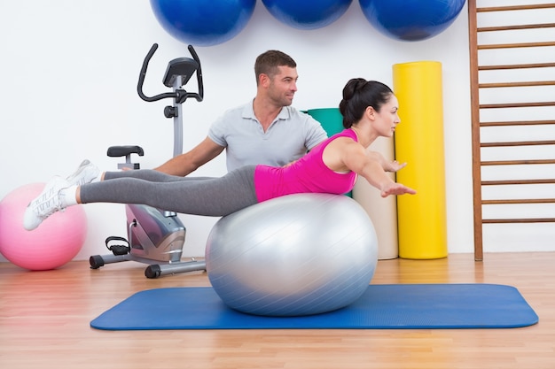 Trainer with woman on exercise ball