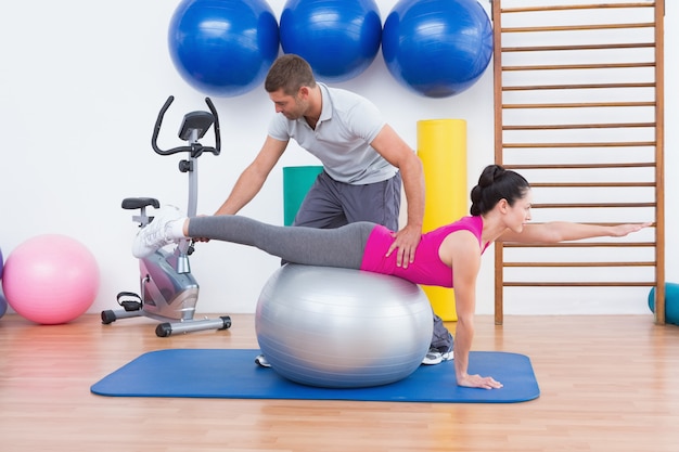 Trainer with woman on exercise ball