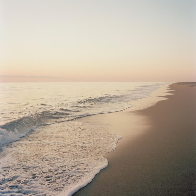 Tranquil beach at sunrise with gentle waves lapping the shore