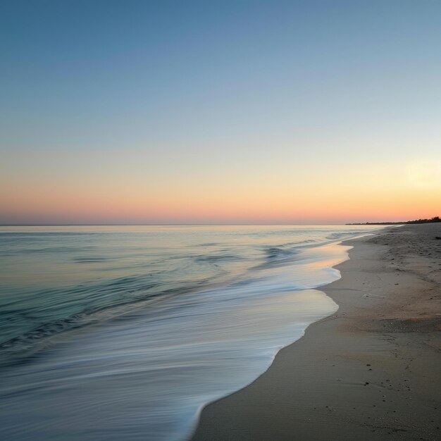 Tranquil ocean waves lapping on a sandy beach at sunset