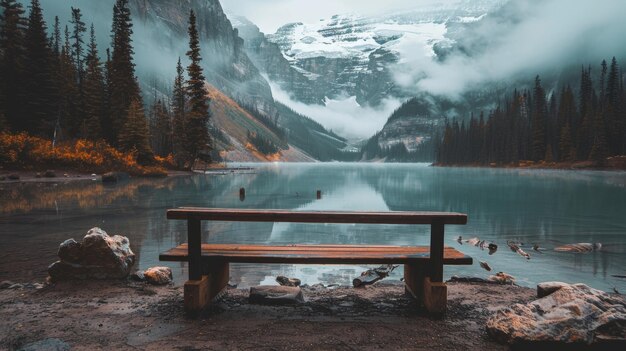 Photo tranquil summer lake mirroring snow capped mountains and fluffy clouds with a scenic bench view