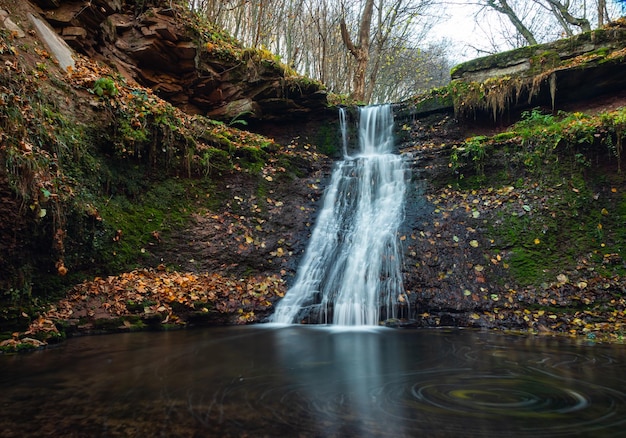 Tranquil waterfall scenery in the middle of autumn forest