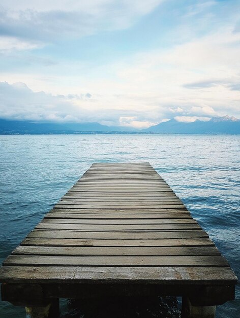 Photo tranquil wooden pier over serene waters with scenic mountain view