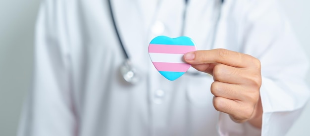 Transgender Day and LGBT pride month LGBTQ or LGBTQIA concept Doctor holding blue pink and white heart shape for Lesbian Gay Bisexual Transgender Queer and Pansexual community