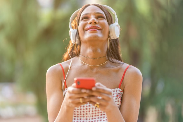 Transgender woman enjoying while listening to music with the mobile