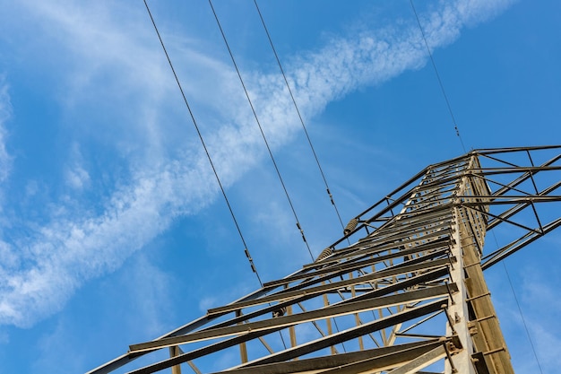 Transmission power lines from below over a clear blue sky