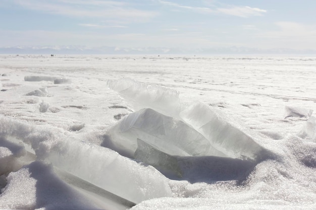 Transparent blue ice hummocks on lake baikal shore siberia winter landscape view snowcovered ice of