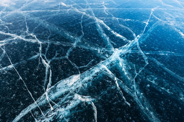 Transparent blue ice with cracks on the lake in winter Baikal Russia