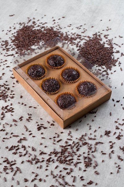 Transparent box full of Brazilian Sweet Brigadeiro on a wooden desk Vegan version