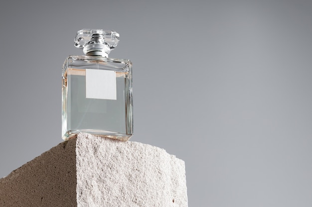 Transparent fragrance bottle on gray .cinder block close up