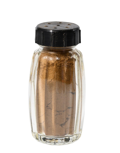 Transparent glass jar with ground cinnamon on a white isolated background spice