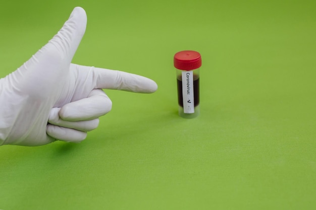 Transparent glass vials with labels and with a test COVID19 vaccine syringe on a desk