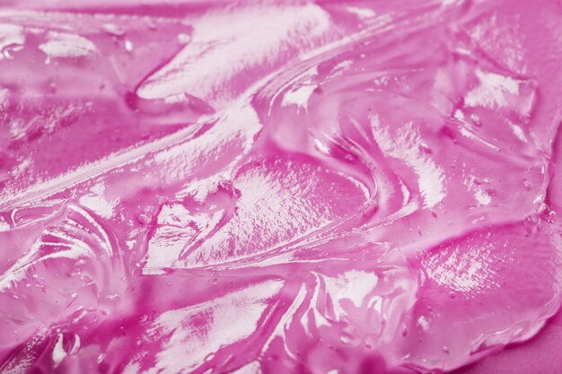 Transparent liquid gel on a pink surface