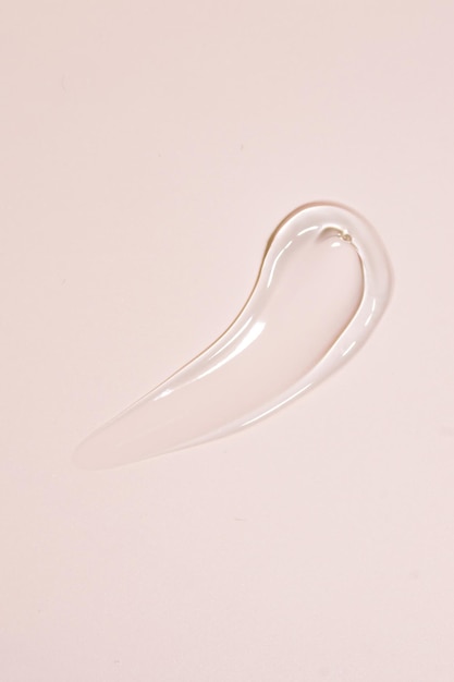 Transparent liquid gel stroke on beige background Cosmetics smear of crystal clear aloe or mucin gel